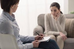 A woman at a prescription drug addiction treatment program discusses a prescription drug rehab in ma with a woman who is considering a presciption drug rehab in massachusetts during the intake process at a substance abuse treatment center in ma
